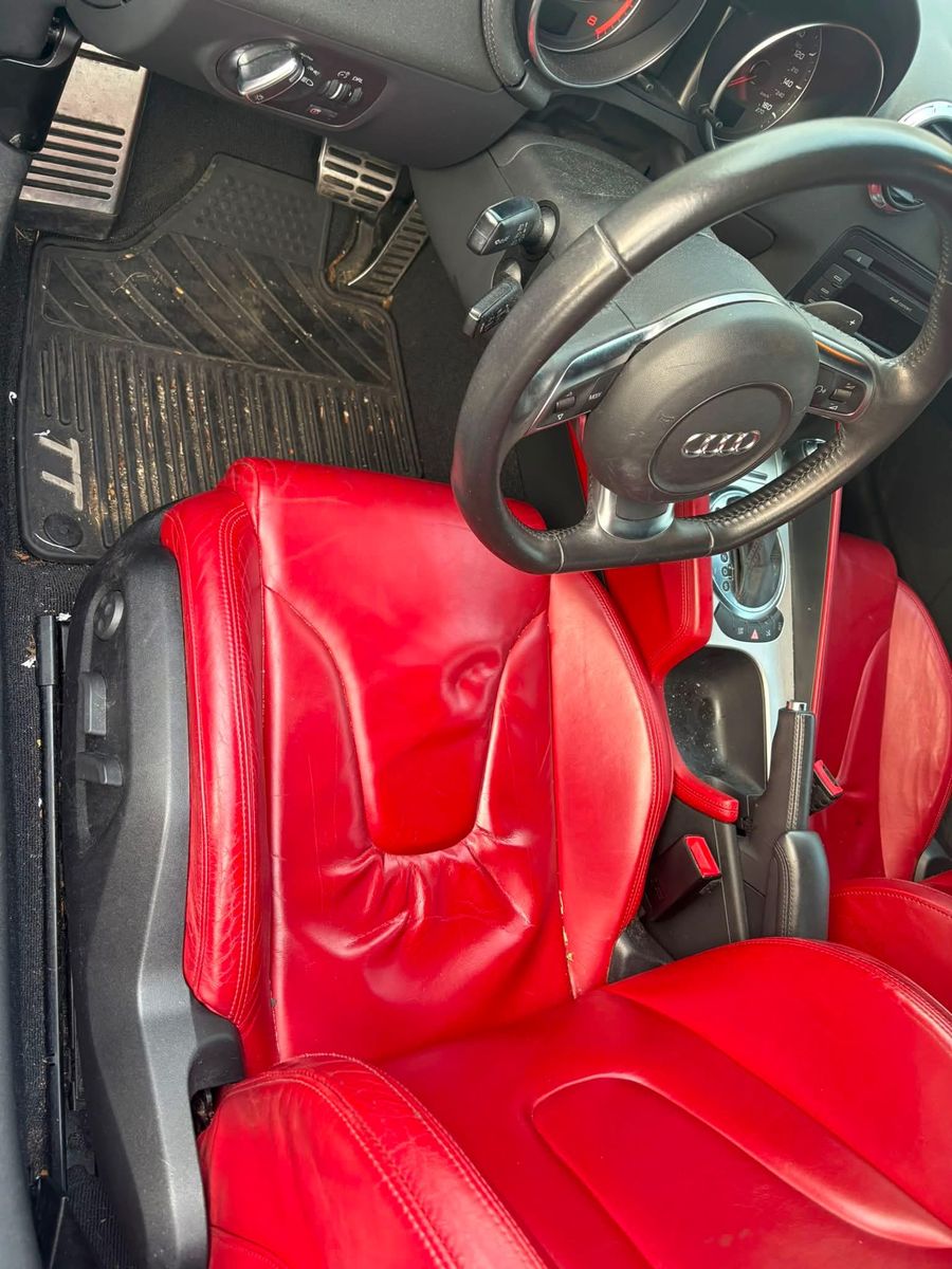 Audi TT driver footwell before detailing — gritty rubber mats and dusty pedals